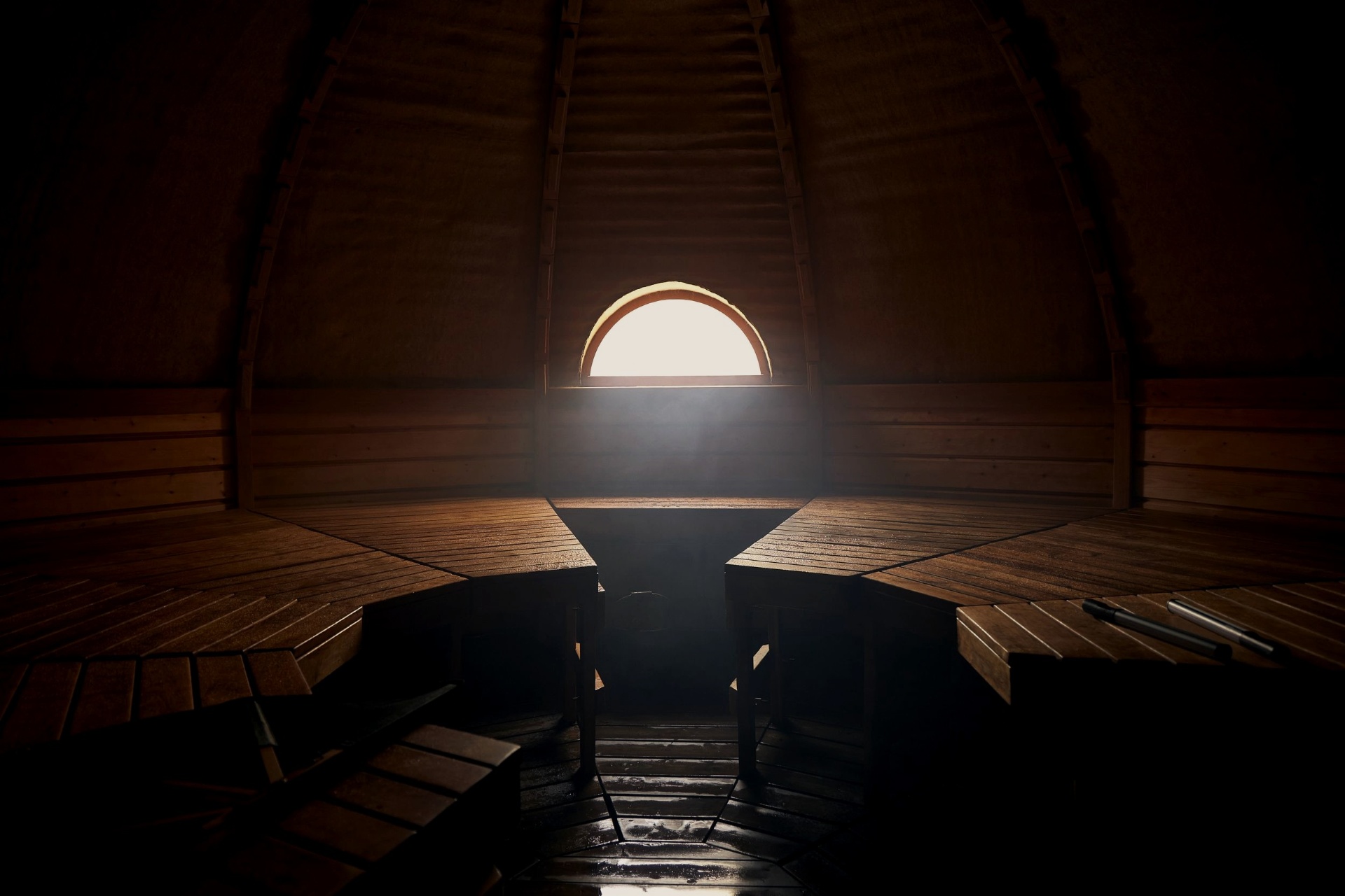 Interior of a dome bathhouse lit only by a glowing arched window