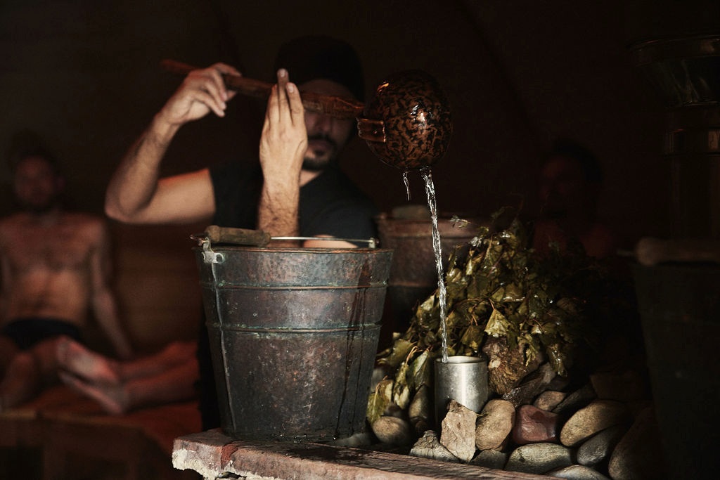 Steam guide pouring water over heated stones