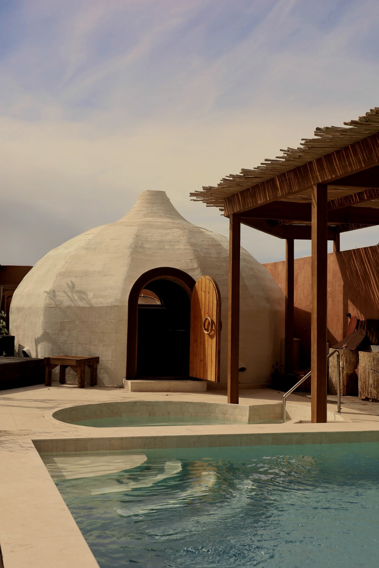 White dome bathhouse beside pools in daylight